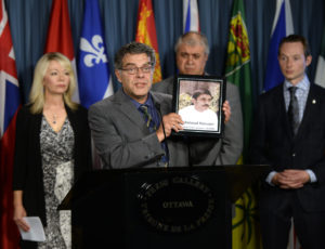 Ahmad Hassani holds a photo of his brother Mahamoud, who was killed in 1988, as members of the Iranian-Canadian community hold a press conference on Parliament Hill in Ottawa, Thursday, Oct. 6, 2016. Photo: Justin Tang