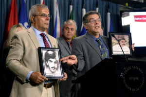 Ahmad Hassani (right) and Mir Garmroud hold photos of their brothers Mahamoud Hassani and Manouchehr Garmroud, both killed in 1988, as members of the Iranian-Canadian community hold a press conference on Parliament Hill in Ottawa, Thursday, Oct. 6, 2016. Photo: Justin Tang