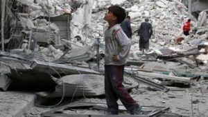 2016104171923589207441_a-boy-inspects-a-damaged-site-after-airstrikes-on