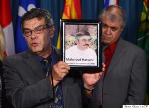 Ahmad Hassani holds up a picture of his brother Mahmoud Hassani, who he says was executed in 1988, as Shahram Golestaneh, right, looks on as they represent the Iranian-Canadian community during a press conference on Parliament Hill in Ottawa on Thursday, Oct. 6, 2016, to shed light on the human rights situation in Iran. THE CANADIAN PRESS/Sean Kilpatrick